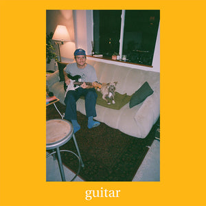 Person playing guitar on a couch with a dog, against a yellow border with 'guitar' text.