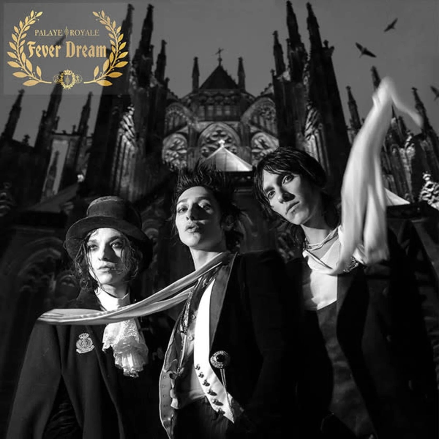 Black and white photo of three people in formal attire with a cathedral in the background, featuring the Palaye Royale logo.